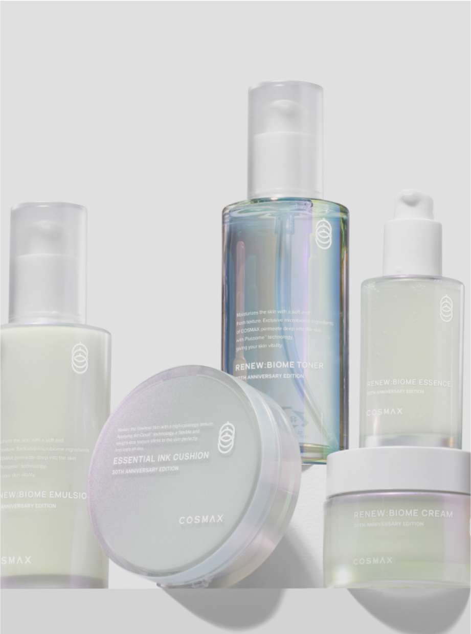 Collection of COSMAX skincare products with pump bottles and a round cream jar on a white surface.